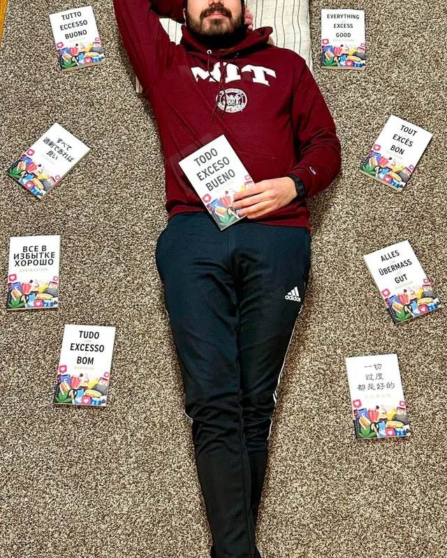 Diego Segura biography photo: in Cambridge, Massachusetts, surrounded by translations of Everything in Excess Is Good